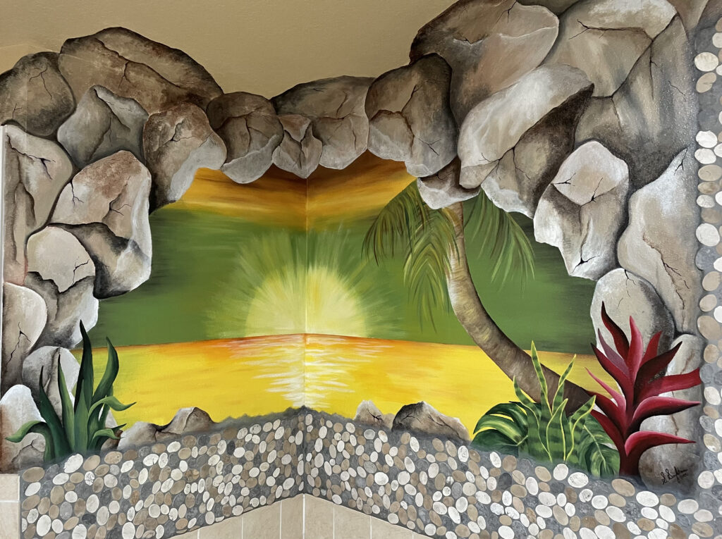 A vibrant mural of a sunset seen through a rocky cave opening.