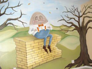 A person with a fishbowl helmet sits on a brick wall in a surreal landscape.