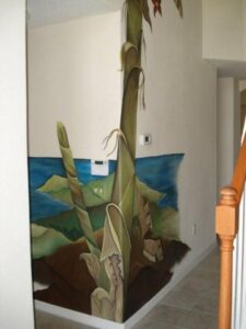 A tall, green succulent plant in a pot near a white wall and staircase.