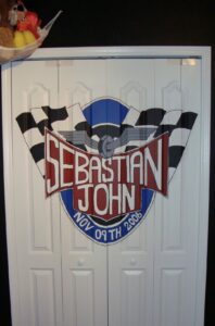 A racing-themed shield logo with checkered flags and the name Sebastian John.