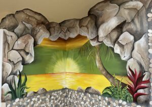A painted mural of a sunset seen through a rocky cave opening.
