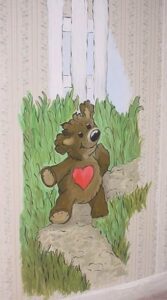 A cute teddy bear with a heart on its chest exploring the forest path.