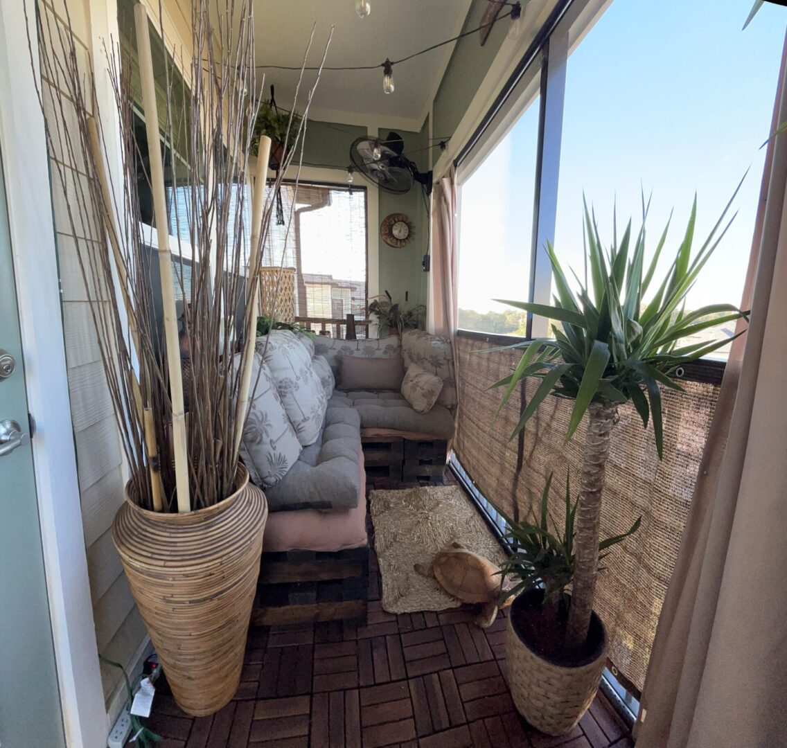 Cozy balcony with plants and seating area.