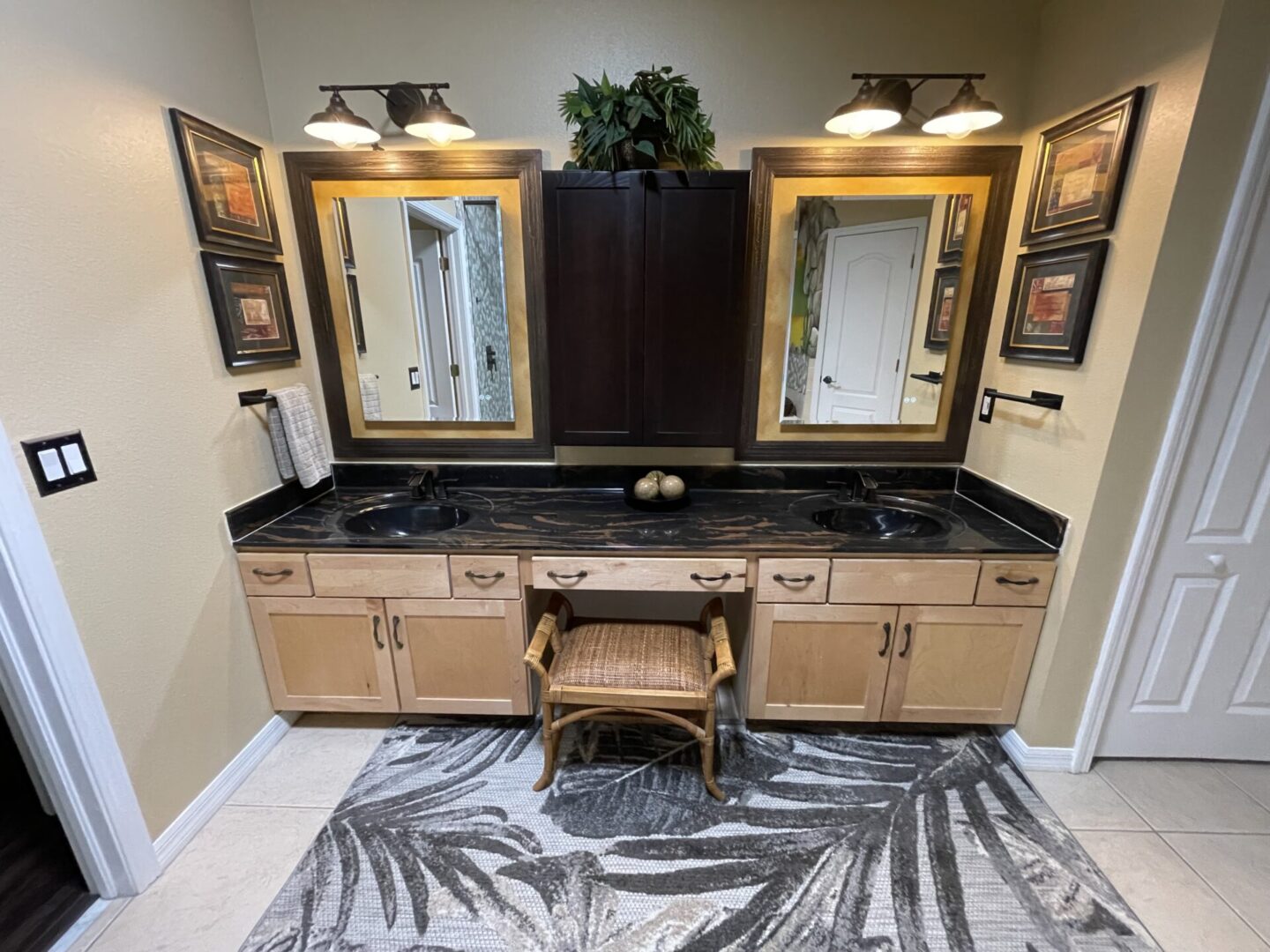 Dual sink bathroom vanity with decorative mirrors.