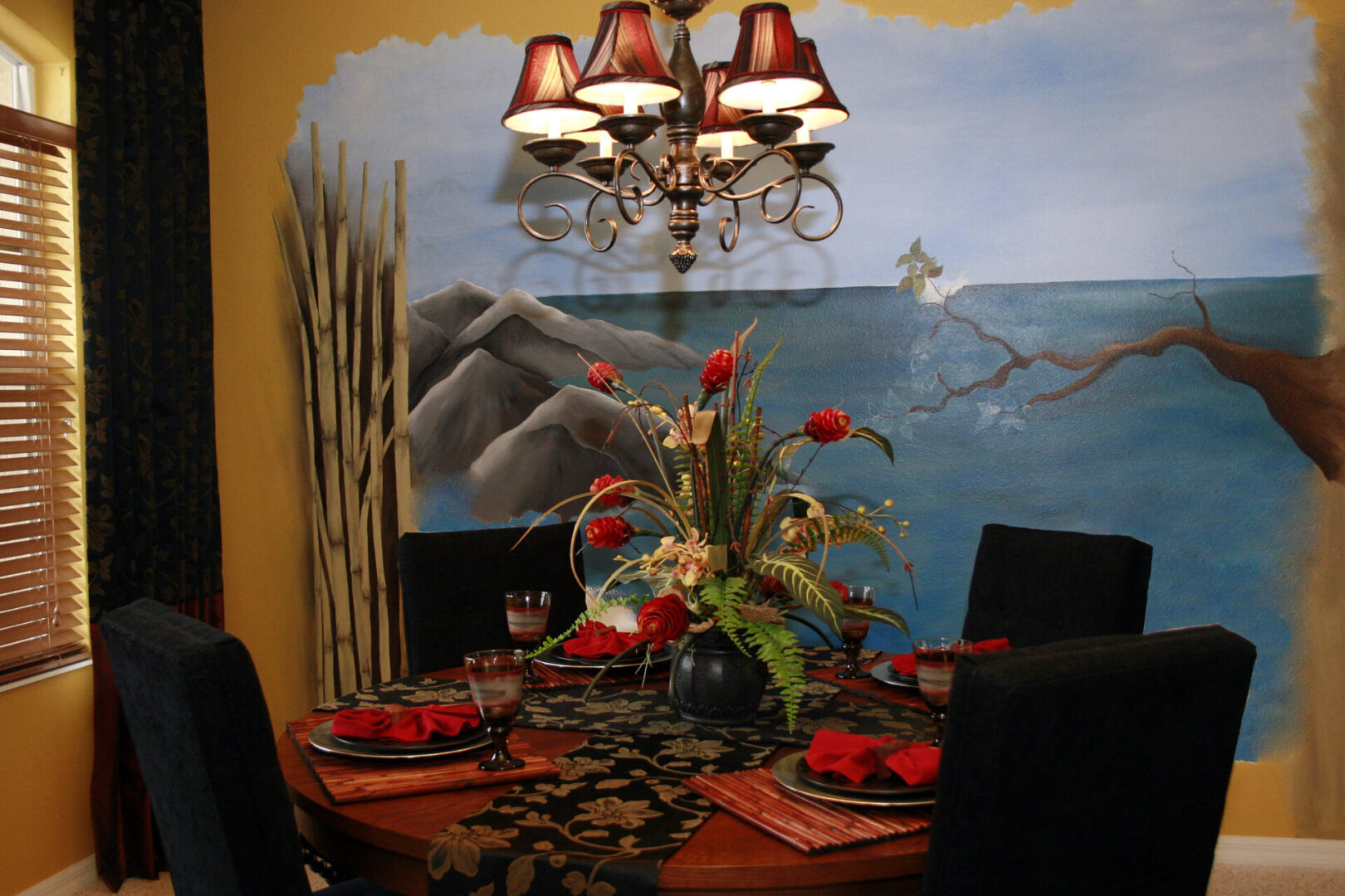 Dining room with ocean-themed mural and chandelier.