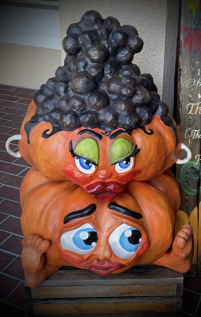 Stacked pumpkins with expressive cartoon faces.