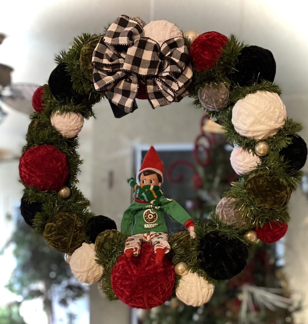 Festive wreath with elf and checkered bow.