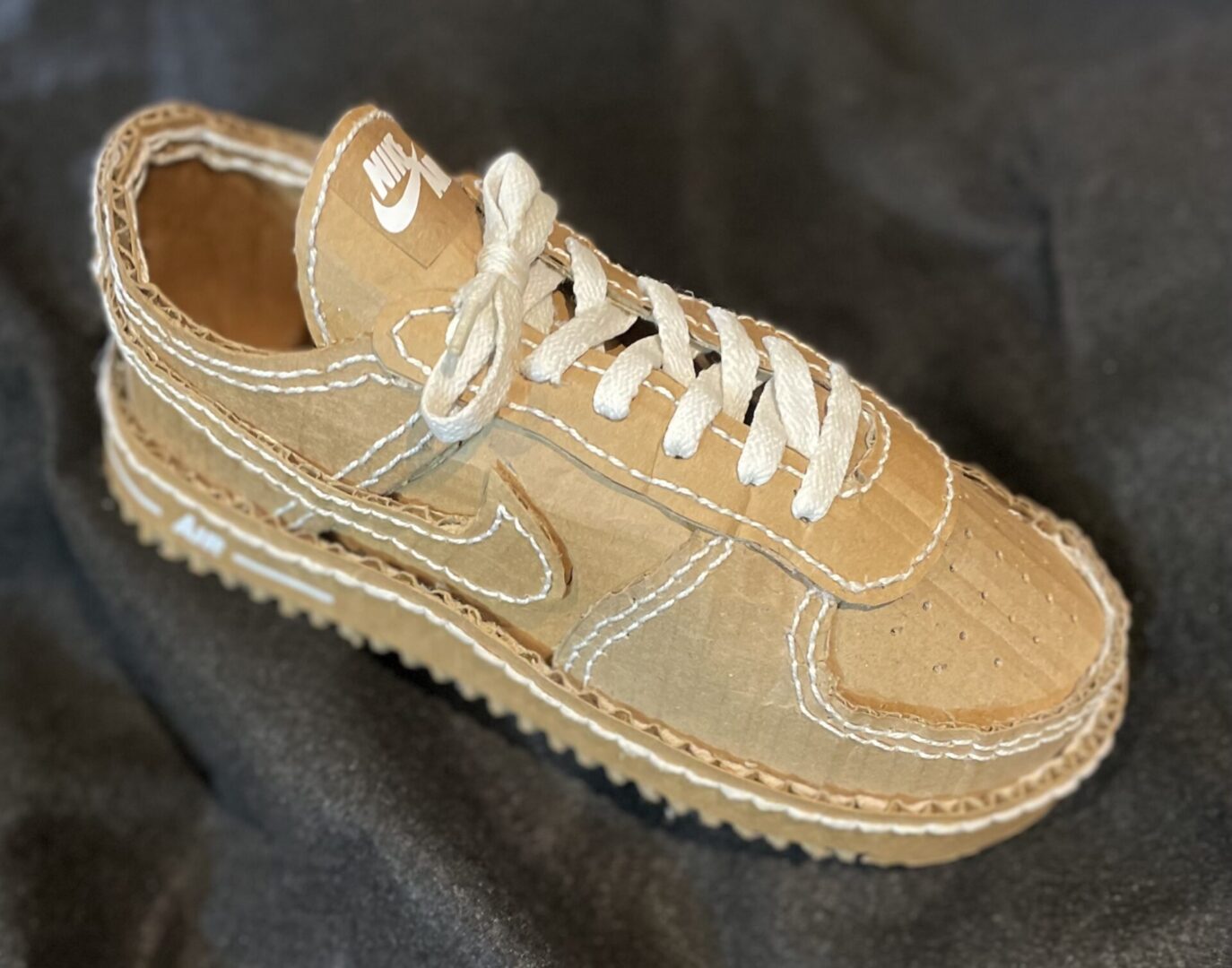 Cardboard sneaker with detailed stitching design.