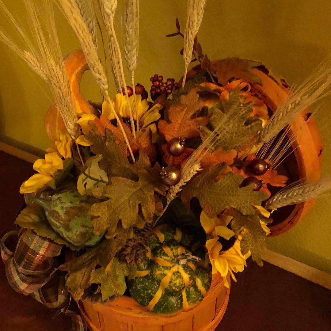Autumn-themed arrangement with leaves and pumpkins.