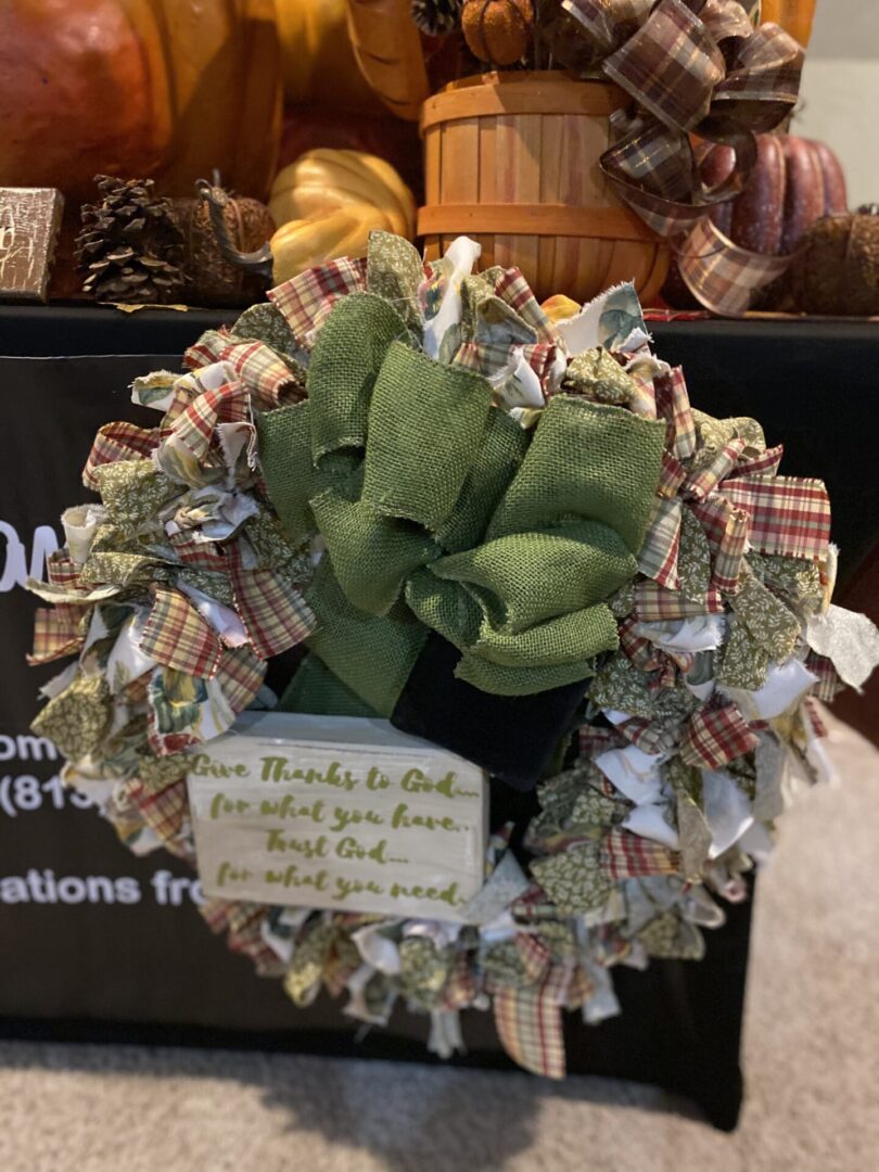 Wreath with green bow and inspirational message.