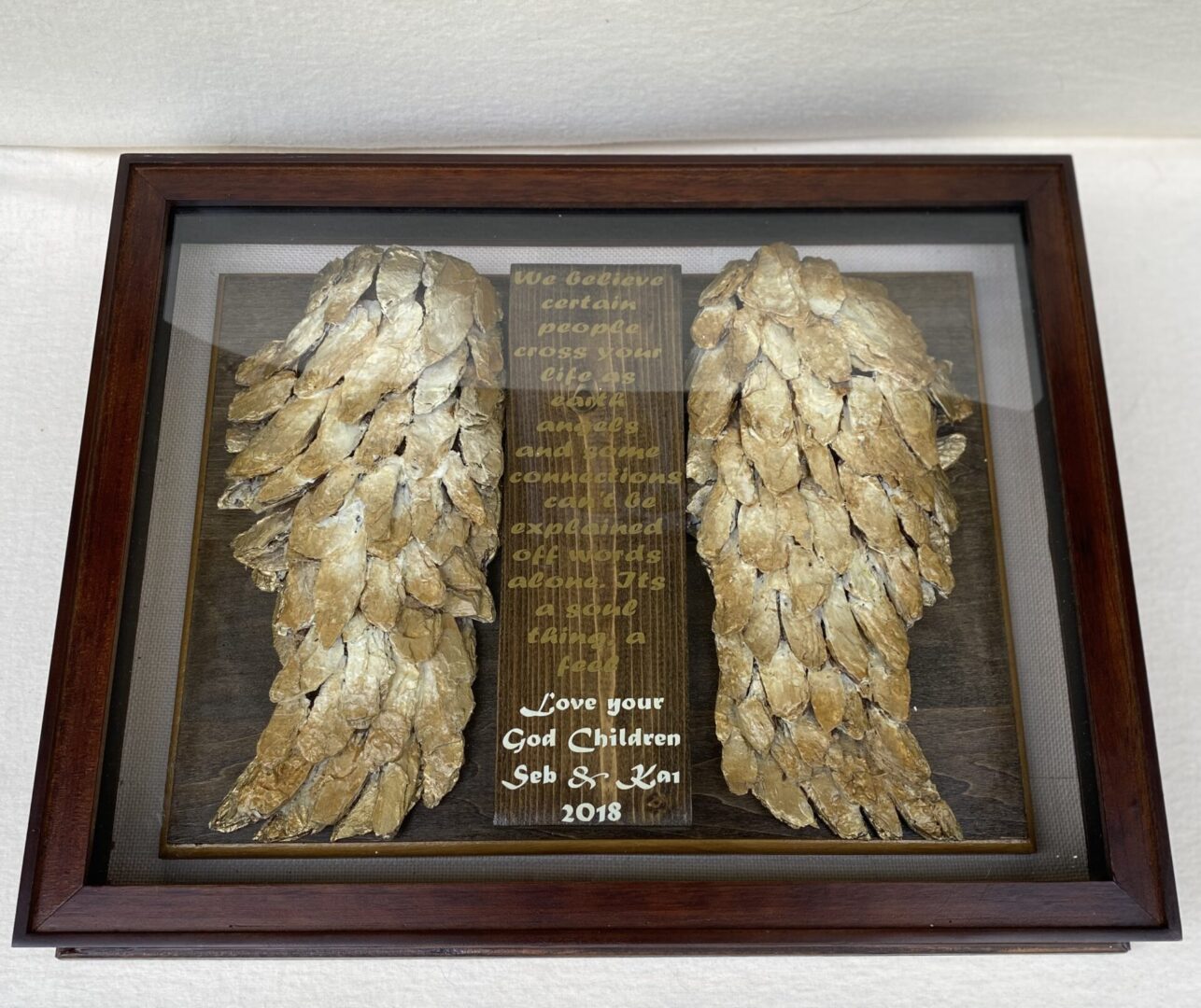 Framed angel wings with engraved dedication plaque.