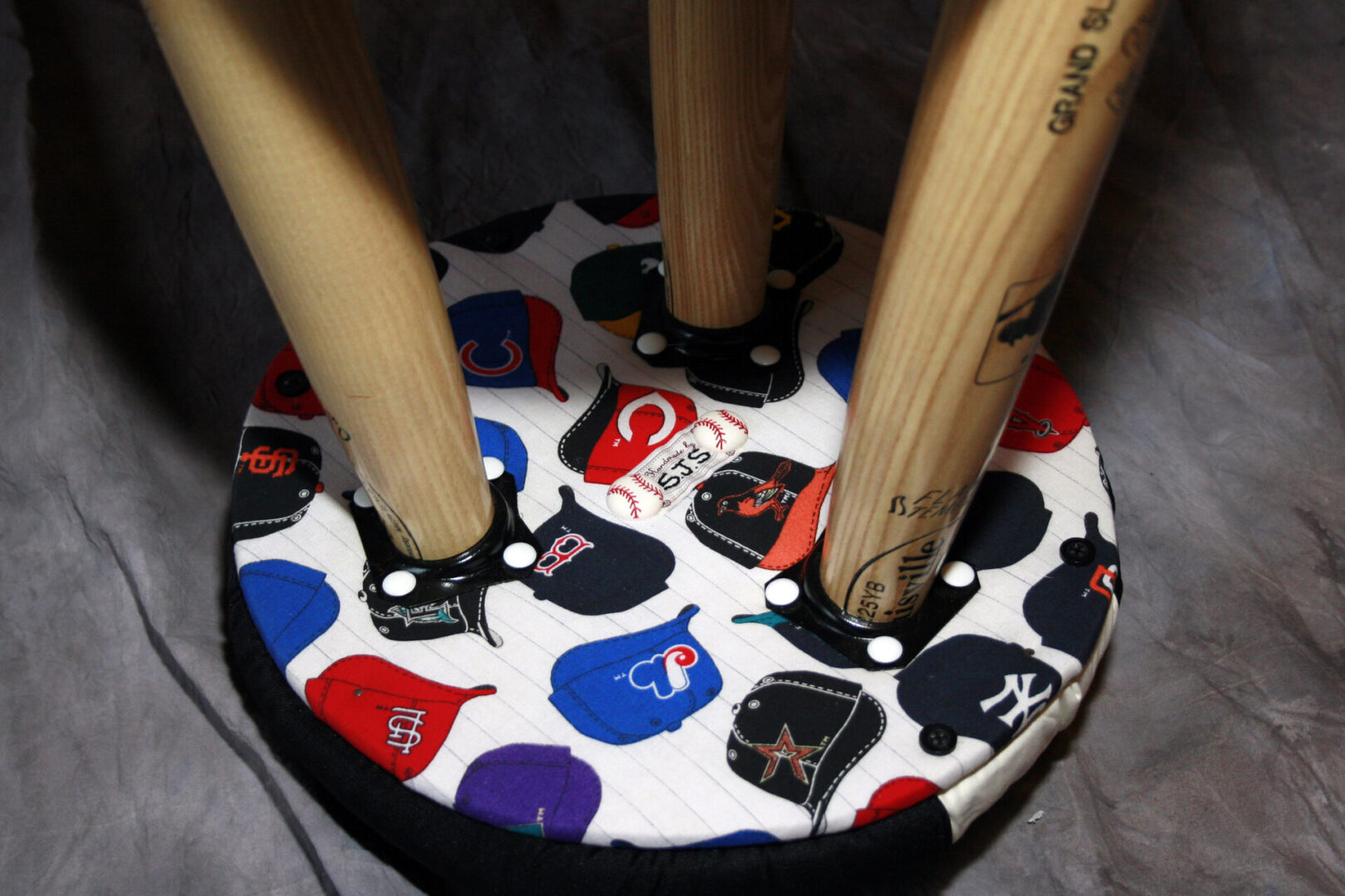 Baseball bat stool with team logos.