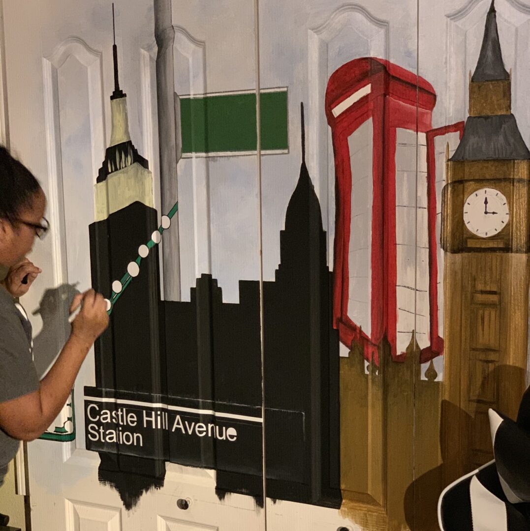 Artist painting cityscape mural with landmarks.